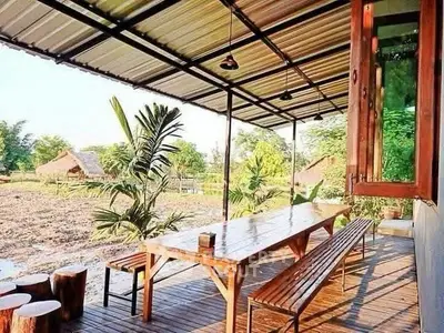 Charming outdoor patio with rustic wooden furniture and scenic countryside view.