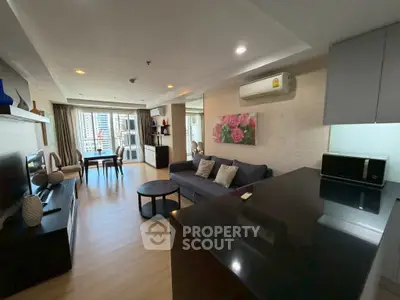 Spacious modern living room with open layout and city view, featuring elegant decor and natural light.