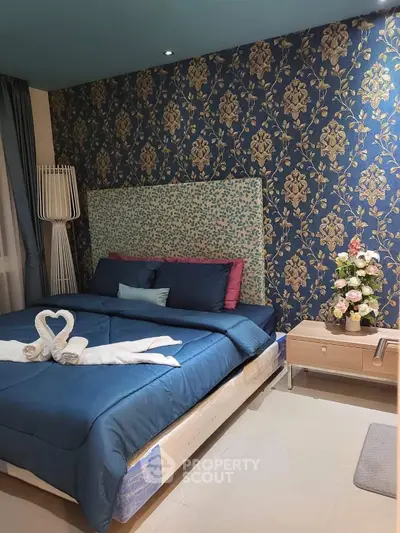 Luxurious bedroom with elegant wallpaper and stylish decor, perfect for a cozy retreat.