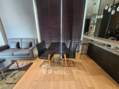 Modern living room with sleek furniture and stylish dining area in open layout apartment.