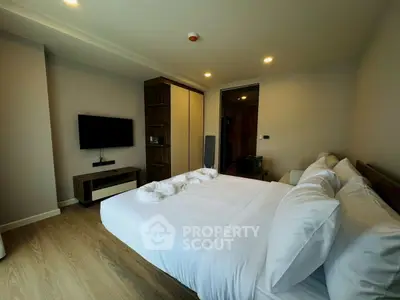 Modern bedroom with cozy lighting and sleek furnishings in a stylish apartment.