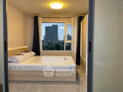 Modern bedroom with city view, featuring sleek furniture and large windows for natural light.