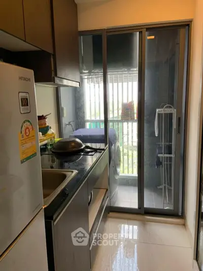 Modern kitchen with sleek design and balcony view, featuring a washing machine and stylish appliances.