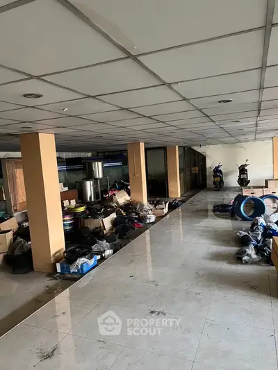 Spacious commercial space with tiled flooring and ample storage potential.