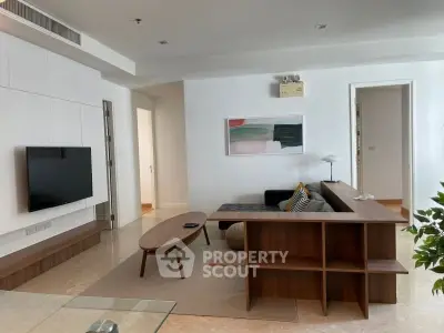 Modern living room with sleek furniture and wall-mounted TV in a stylish apartment.