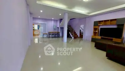 Spacious open-plan living room with modern decor and staircase