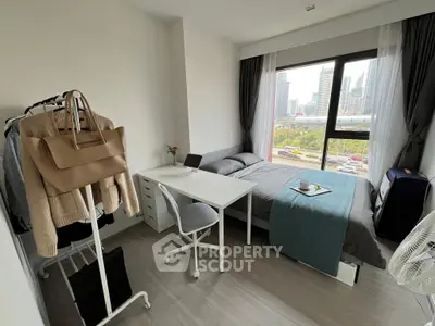 Modern studio apartment with ample natural light, featuring a cozy sleeping area, a dedicated workspace, and a stylish interior design, perfect for urban living.
