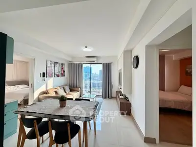 Spacious modern living room with dining area and balcony view in a stylish apartment.