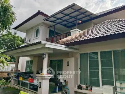 Charming two-story house with tiled roof and spacious balcony in lush green setting.