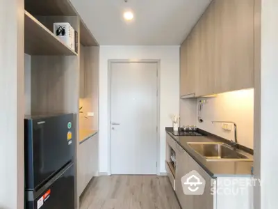 Modern kitchen with sleek cabinetry and stainless steel appliances in a compact layout