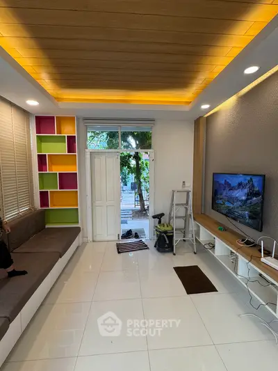 Modern living room with stylish ceiling lights and colorful shelving