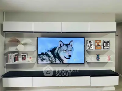 Modern living room with sleek white shelving and wall-mounted TV displaying a wolf image.