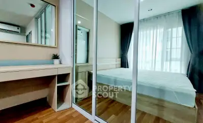 Modern bedroom with mirrored wardrobe and wooden flooring in a stylish apartment.
