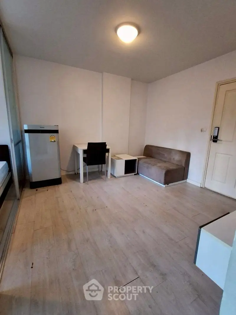 Cozy minimalist living room with sofa and desk, ideal for small spaces.