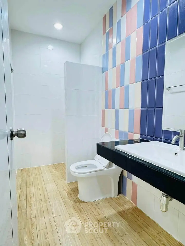 Modern bathroom with colorful tiled wall and sleek fixtures