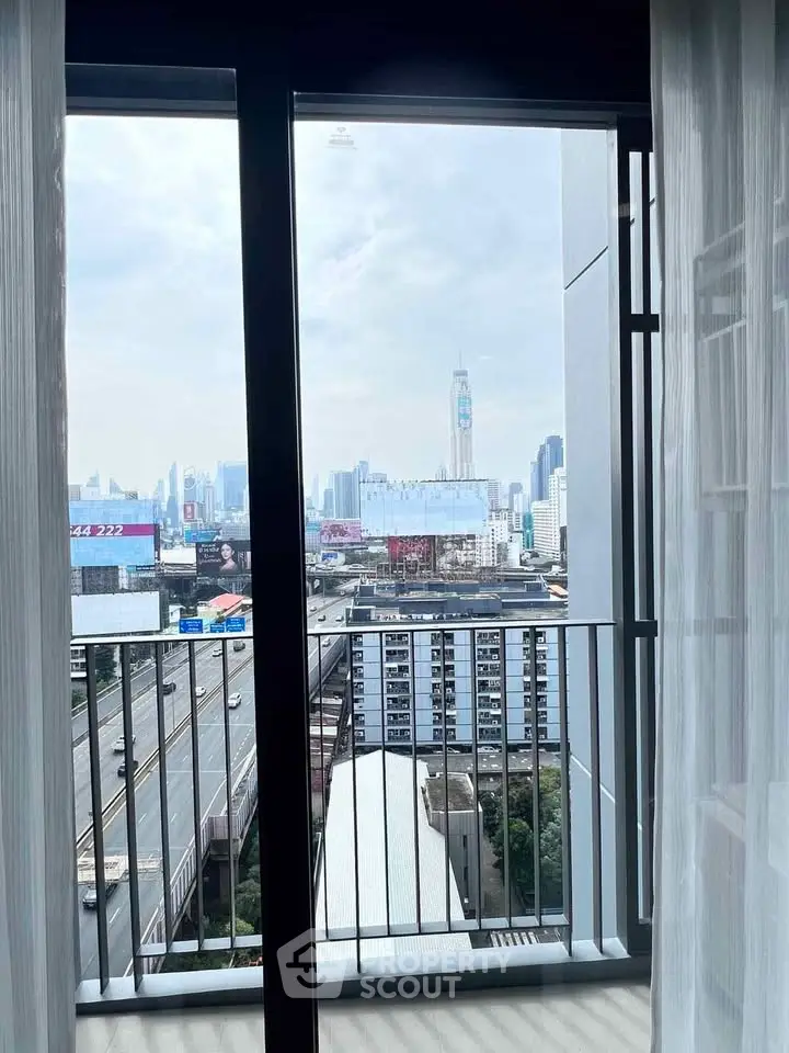 Stunning city view from a modern apartment balcony with floor-to-ceiling windows.