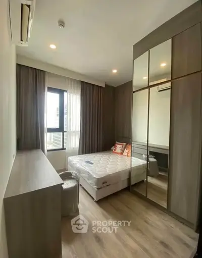 Modern bedroom with mirrored wardrobe and large window in stylish apartment