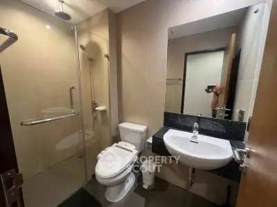 Modern bathroom with glass shower and sleek fixtures in a contemporary home.