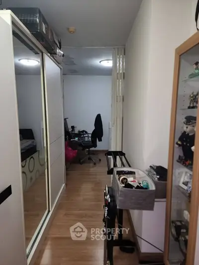 Compact bedroom with mirrored wardrobe and study area, ideal for urban living.