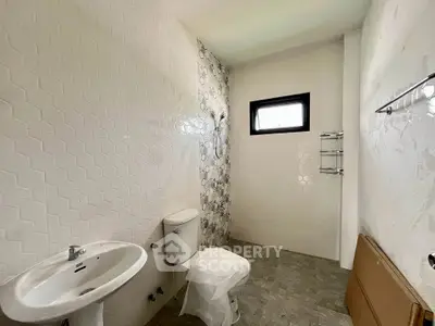 Modern minimalist bathroom with geometric tiles and compact fixtures