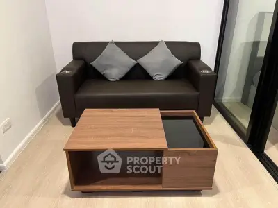 Modern living room with sleek black sofa and stylish wooden coffee table on light wood flooring.