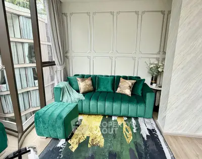 Luxurious living room with green velvet sofa and modern decor in high-rise apartment.