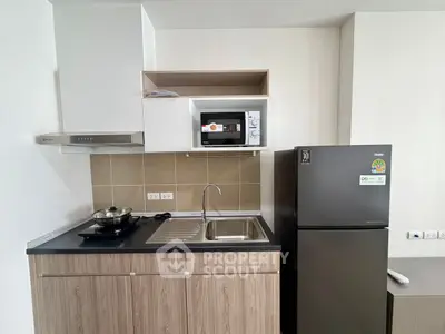 Modern kitchen with sleek appliances and stylish cabinetry in a contemporary apartment.