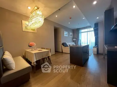 Modern open-plan living room with elegant chandelier and cozy dining area