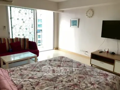 Spacious bedroom with modern decor and large window offering city views.