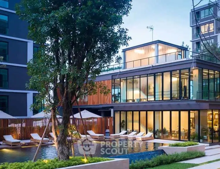 Luxurious modern building with poolside view and lush greenery, perfect for upscale living.