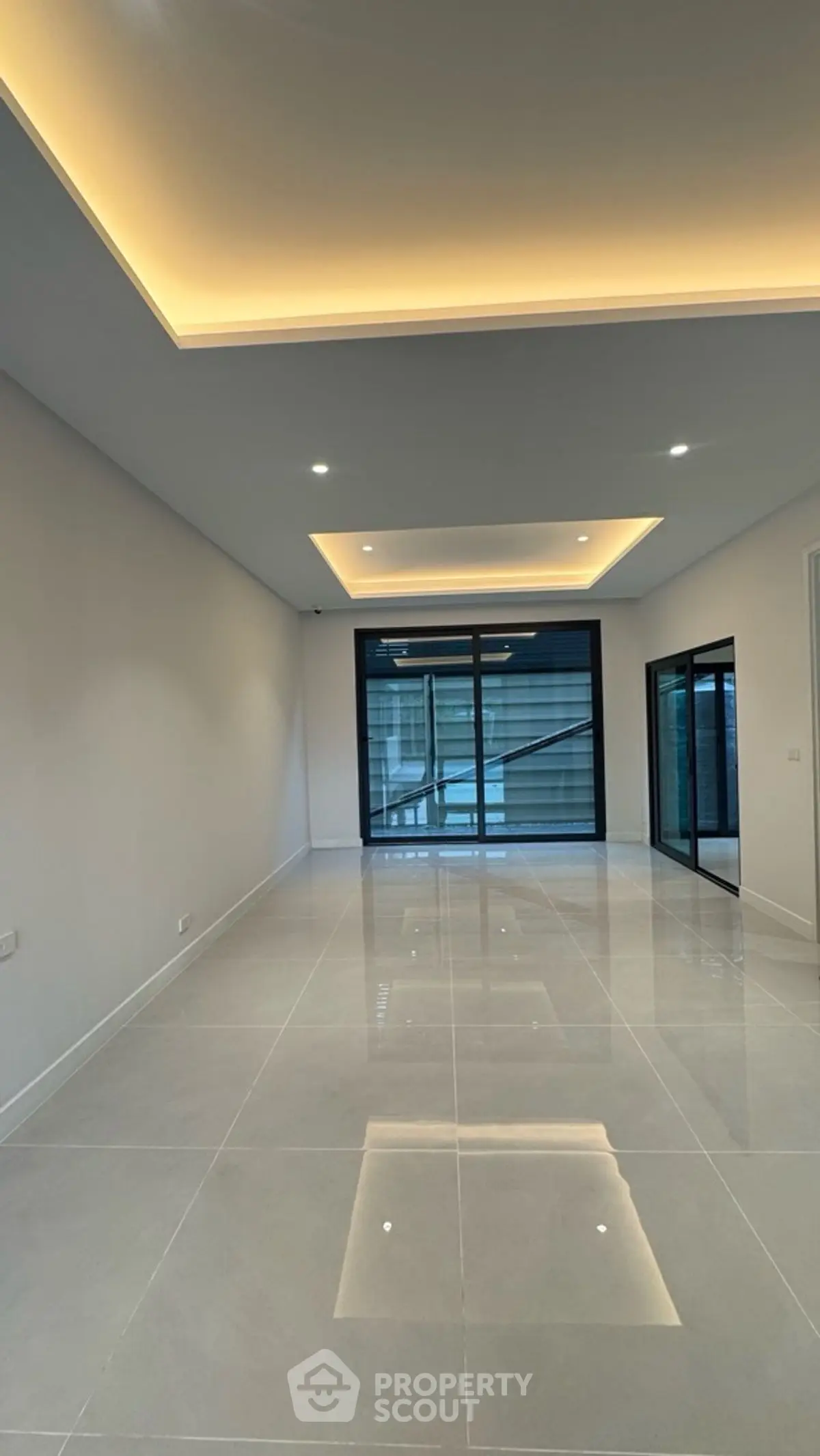 Spacious modern living room with sleek tile flooring and recessed lighting