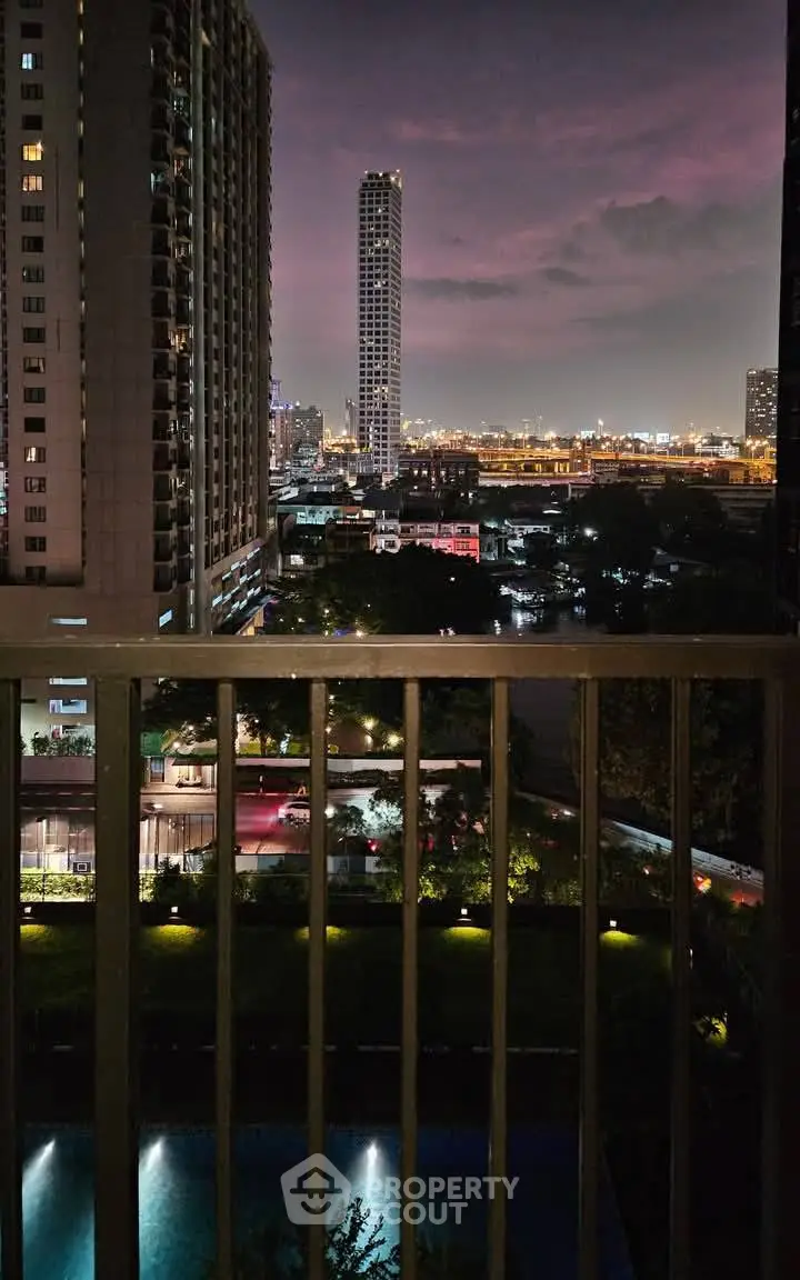 Stunning cityscape view from a balcony at night with illuminated buildings and serene ambiance.