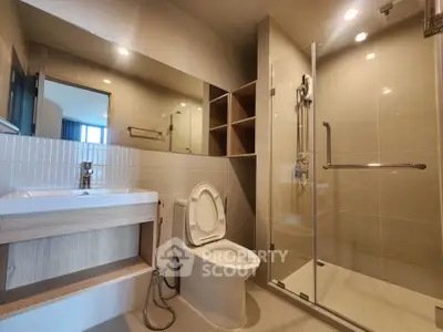 Modern bathroom with glass shower and sleek fixtures in a contemporary apartment.