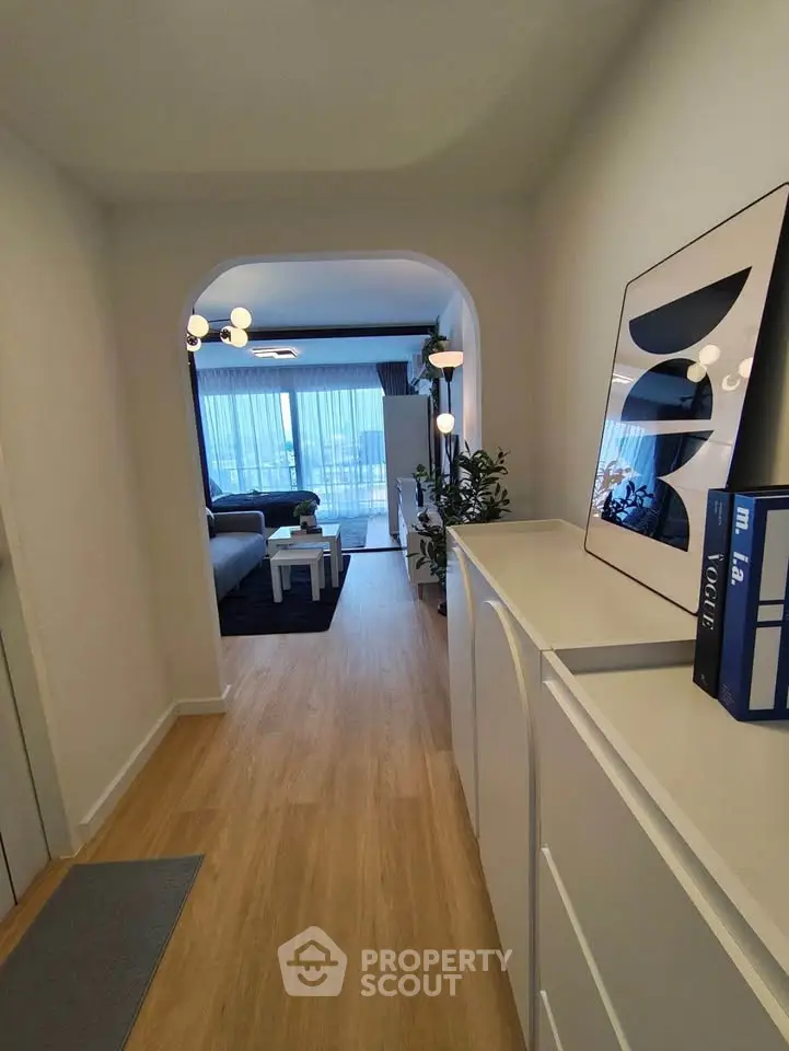 Stylish hallway leading to a modern living room with elegant decor and natural light.