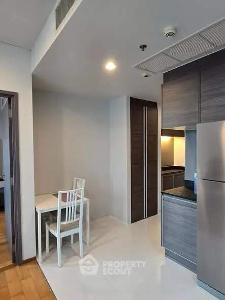 Modern kitchen with sleek cabinetry and dining area in a stylish apartment