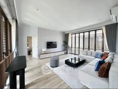 Spacious modern living room with large windows and stylish decor, perfect for relaxation and entertainment.