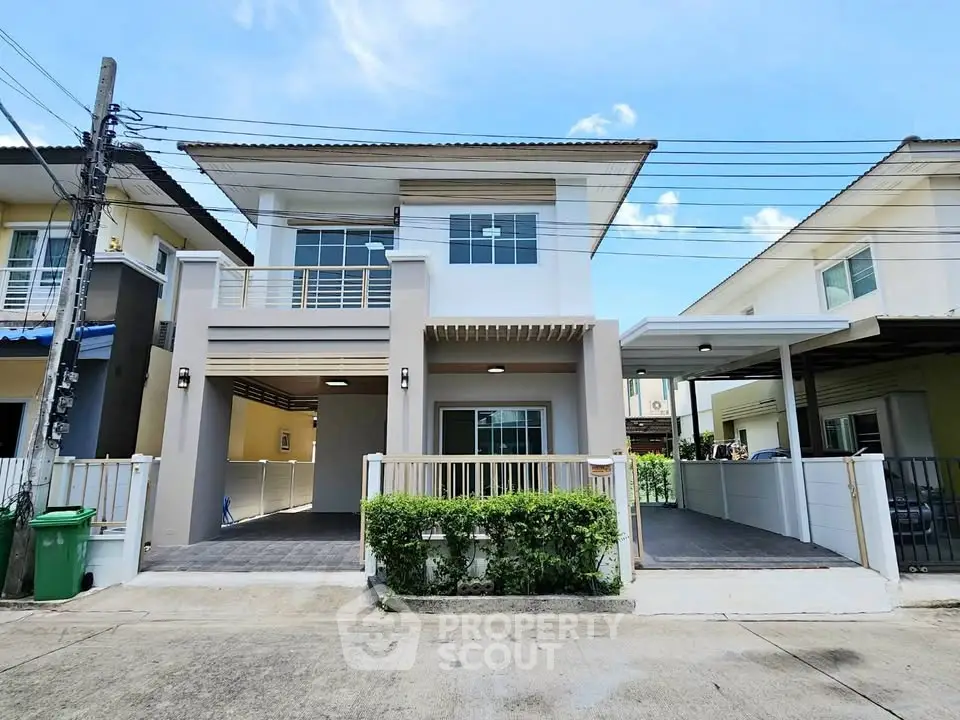 Modern two-story house with driveway and balcony in suburban neighborhood