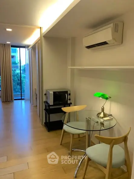Modern studio apartment with air conditioning and stylish furniture, featuring a cozy dining area and natural light.