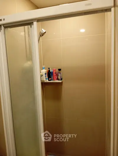 Modern bathroom with glass shower enclosure and built-in shelf