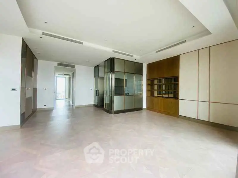 Spacious modern living room with sleek built-in storage and elegant flooring.