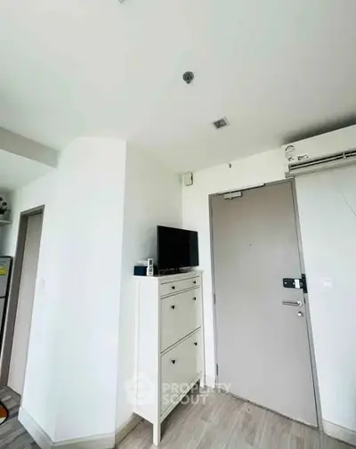 Modern apartment entrance with sleek door and compact storage unit