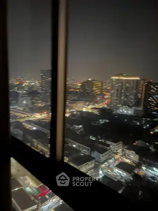 Stunning cityscape view from high-rise apartment window at night, showcasing vibrant urban lights.