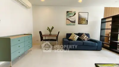 Modern living room with stylish furniture and elegant decor, featuring a cozy sofa and chic dining area.