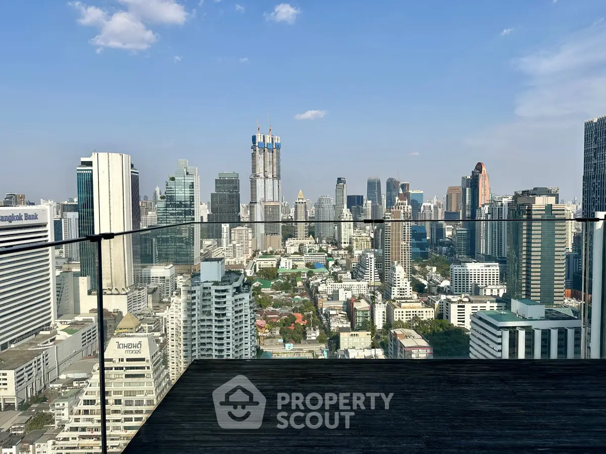 Stunning cityscape view from a modern balcony with glass railing, perfect for urban living.