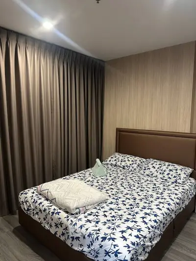 Cozy bedroom with stylish decor and elegant curtains, perfect for relaxation.