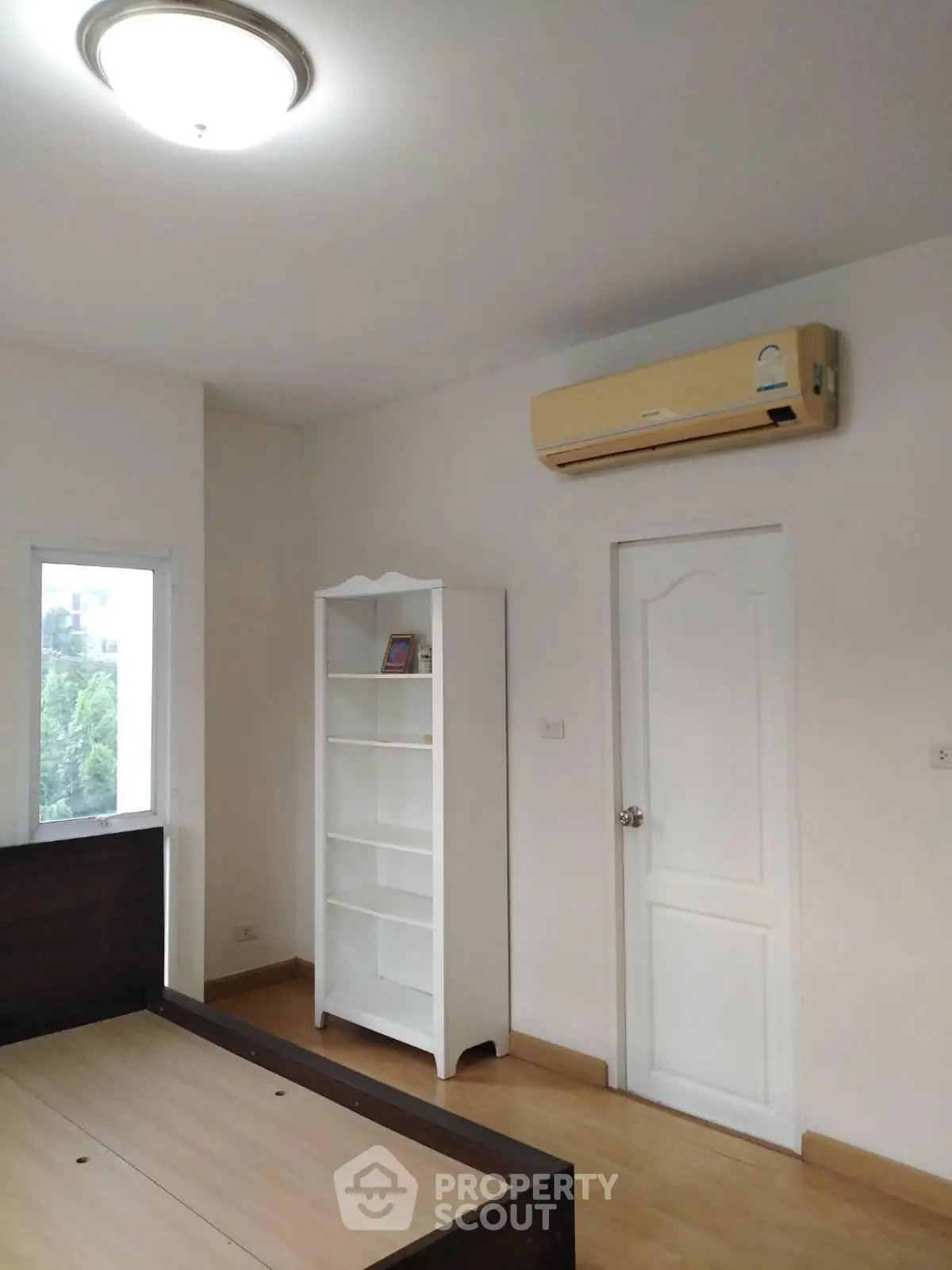 Bright bedroom with air conditioning and white shelving unit