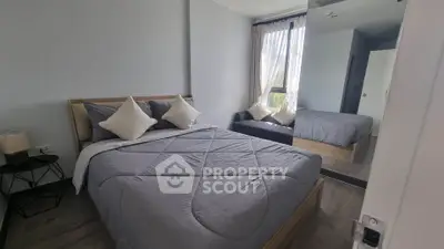 Cozy bedroom with modern decor and large mirror reflecting natural light.