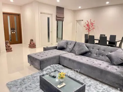 Luxurious living room with plush gray sectional sofa and elegant dining area