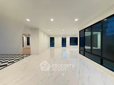 Spacious modern living room with large windows and elegant marble flooring.