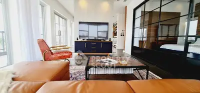 Luxurious modern living room with leather sofa, stylish decor, and large windows offering abundant natural light.